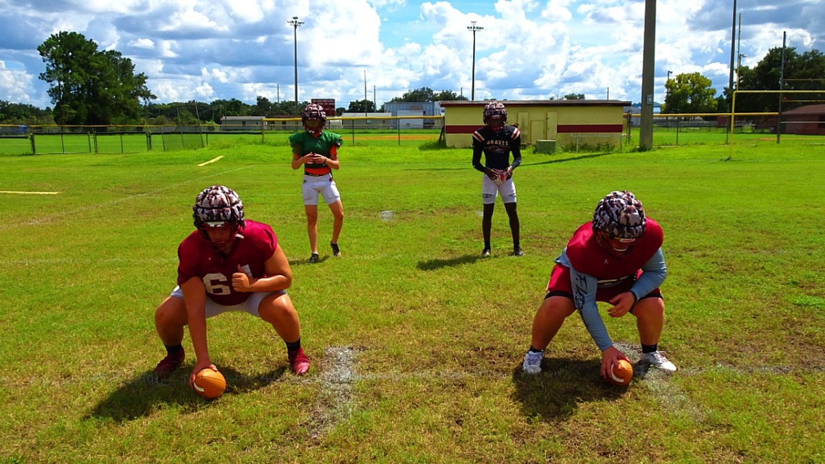 Lake Gibson athlete Sam McCall (right) and quarterback Logan Hackett (left) practice receiving snaps. Credit: Zach Goodall, Sports Illustrated media