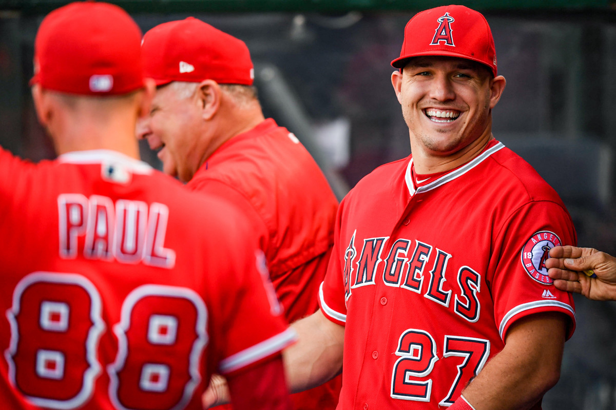 Mike Trout smiles while in the Angels dugout