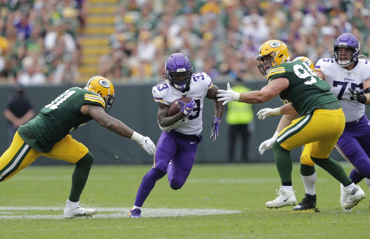 Sep 15, 2019; Green Bay, WI, USA; Minnesota Vikings running back Dalvin Cook (33) runs for a gain against Green Bay Packers outside linebacker Preston Smith (91) and Dean Lowry (94) in the third quarter during their football game Sunday, September 15, 2019, at Lambeau Field in Green Bay, Wis. Mandatory Credit: Dan Powers/USA TODAY NETWORK