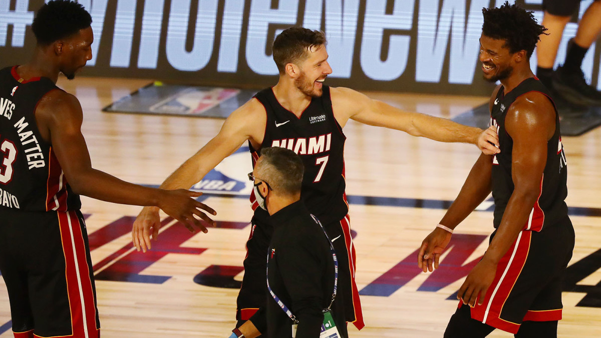 Miami Heat forward Jimmy Butler celebrates with guard Goran Dragic and forward Bam Adebayo after defeating the Milwaukee Bucks