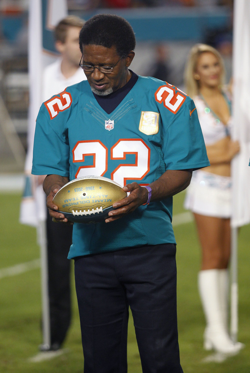 Former Dolphins running back Mercury Morris holds his commemorative ball during a halftime ceremony at Sun Life Stadium where he was named a member of the franchise's all-time team.