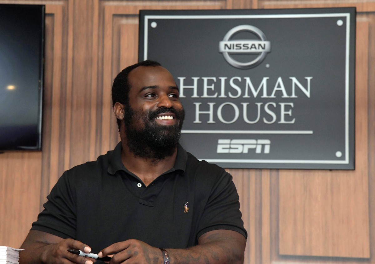 Former Dolphins running back and 1998 Heisman Trophy winner Ricky Williams signs autographs at the ESPN Heisman House at Darrell K. Royal-Texas Memorial Stadium in 2018.