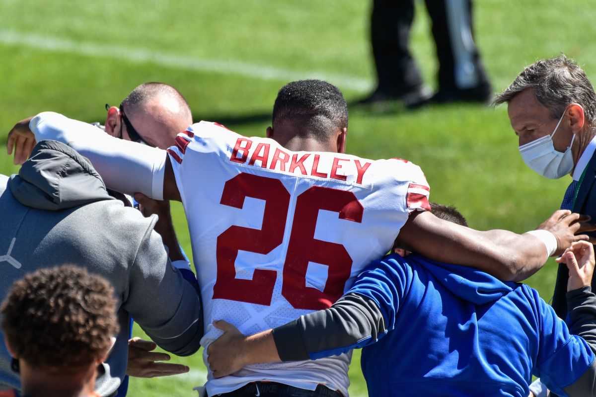Sep 20, 2020; Chicago, Illinois, USA; New York Giants running back Saquon Barkley (26) is helped off of the field after suffering an injury during the second quarter against the Chicago Bears at Soldier Field.