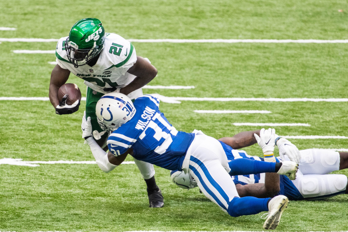 New York Jets running back Frank Gore (21) is tackled by Indianapolis Colts defensive back Tavon Wilson (31) in the second half of Sunday's game at Lucas Oil Stadium.