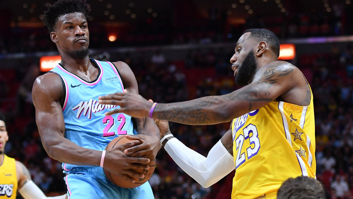 Miami Heat forward Jimmy Butler and Los Angeles Lakers forward LeBron James battle for the ball