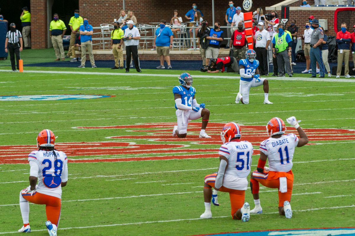 Mississippi Rebels and Florida Gators players kneel before the game Saturday at Vaught-Hemingway Stadium.