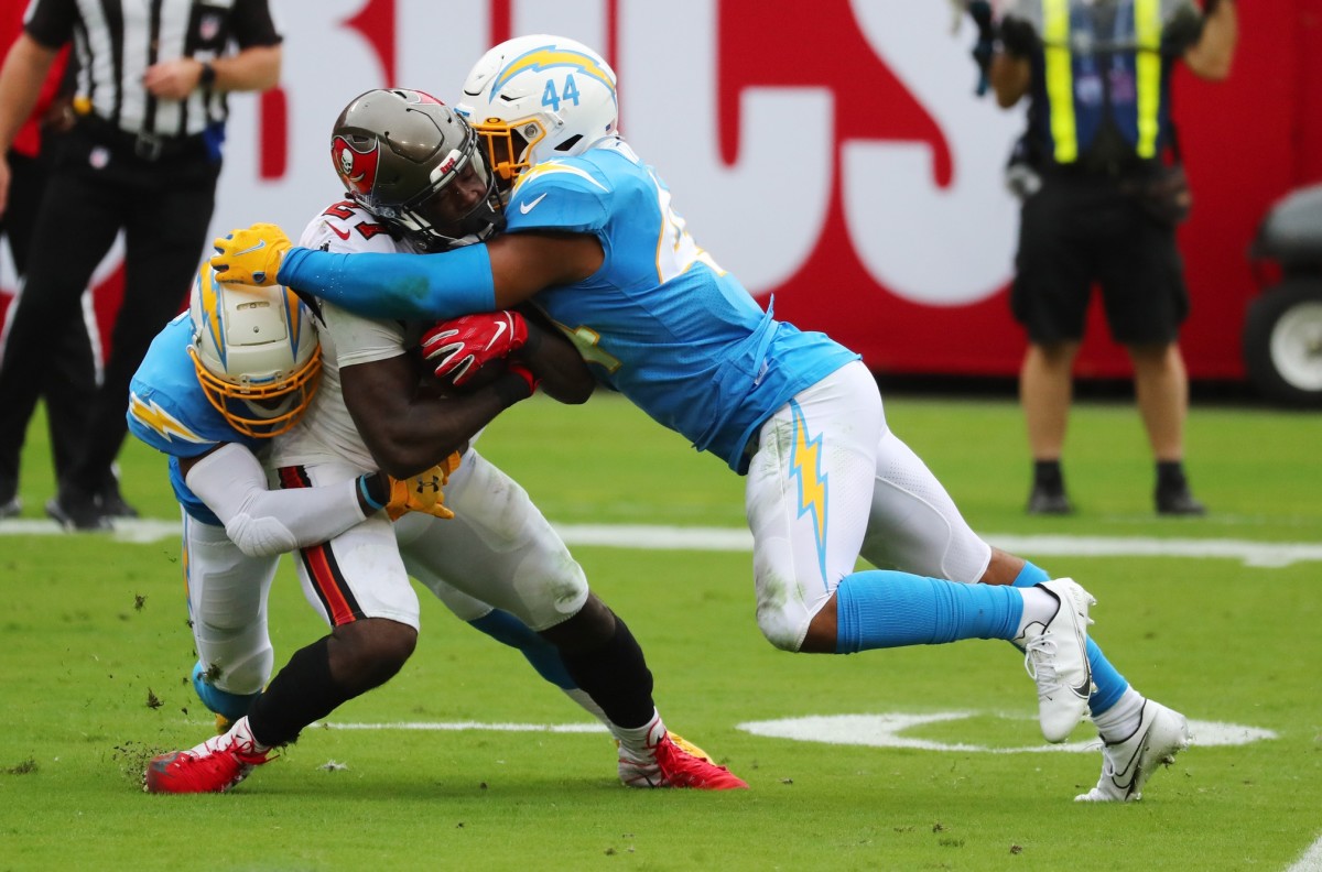 Tampa Bay Buccaneers running back Ronald Jones (27) is tackled by Los Angeles Chargers outside linebacker Kyzir White (44) and cornerback Michael Davis (43) in the first quarter of a NFL game at Raymond James Stadium.
