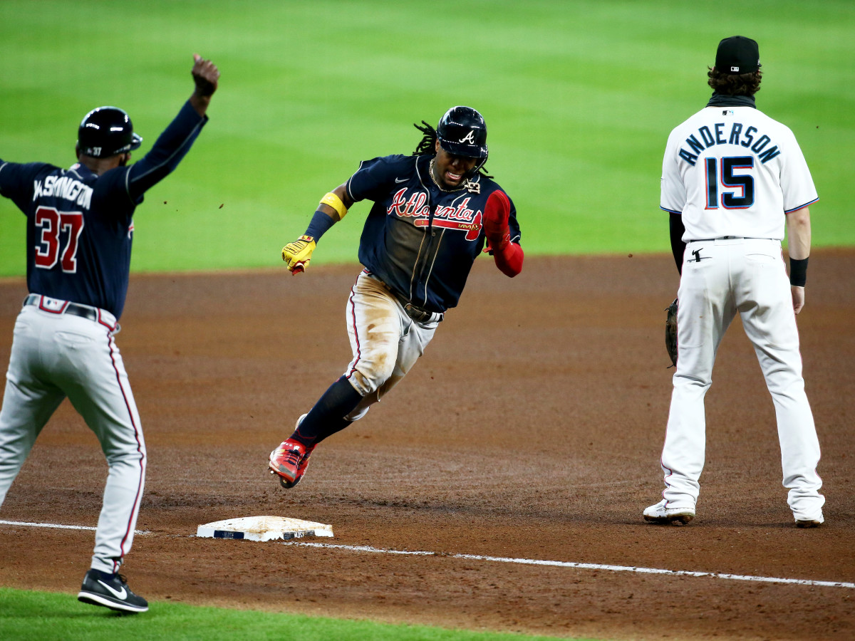 Oct 8, 2020; Houston, Texas, USA; Atlanta Braves center fielder Ronald Acuña Jr. (13) rounds third base against Miami Marlins third baseman Brian Anderson (15) to score a run during the fourth inning of game three of the 2020 NLDS at Minute Maid Park.