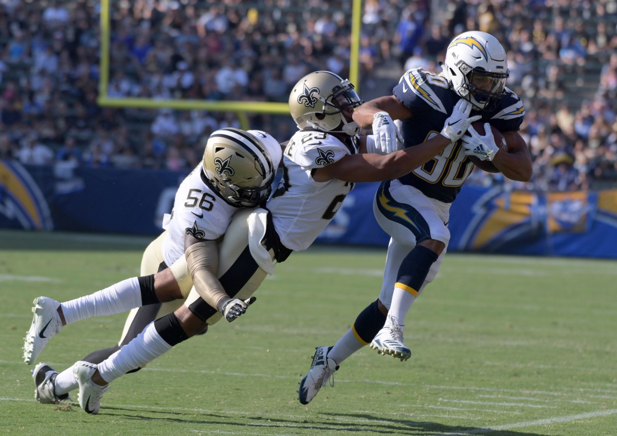 Aug 25, 2018; Carson, CA, USA; Los Angeles Chargers running back Austin Ekeler (30) is tackled by New Orleans Saints cornerback Marshon Lattimore (23) and linebacker Demario Davis (56) during a preseason game at StubHub Center. The Saints defeated the Chargers 36-7. Mandatory Credit: Kirby Lee-USA TODAY