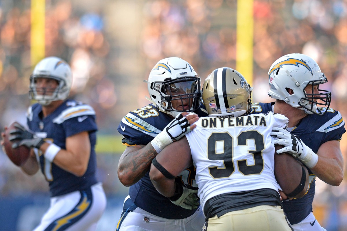 Aug 25, 2018; Carson, CA, USA; Los Angeles Chargers center Mike Pouncey (53) and offensive guard Dan Feeney (66) block New Orleans Saints defensive tackle David Onyemata (93) as quarterback Philip Rivers (left, background) looks to pass at StubHub Center. Mandatory Credit: Jake Roth-USA TODAY