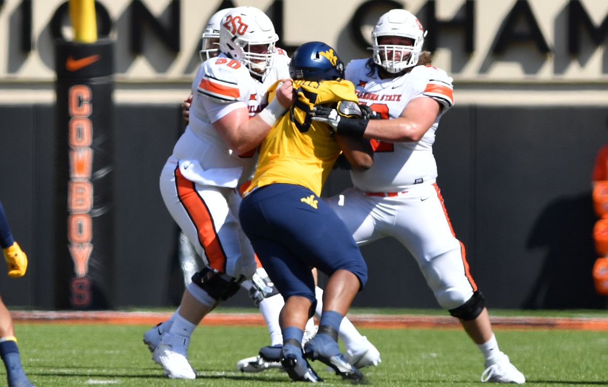 Sills (72) and teammate and center Ry Schneider (50) combine to block West Virginia lineman Dante Stills.