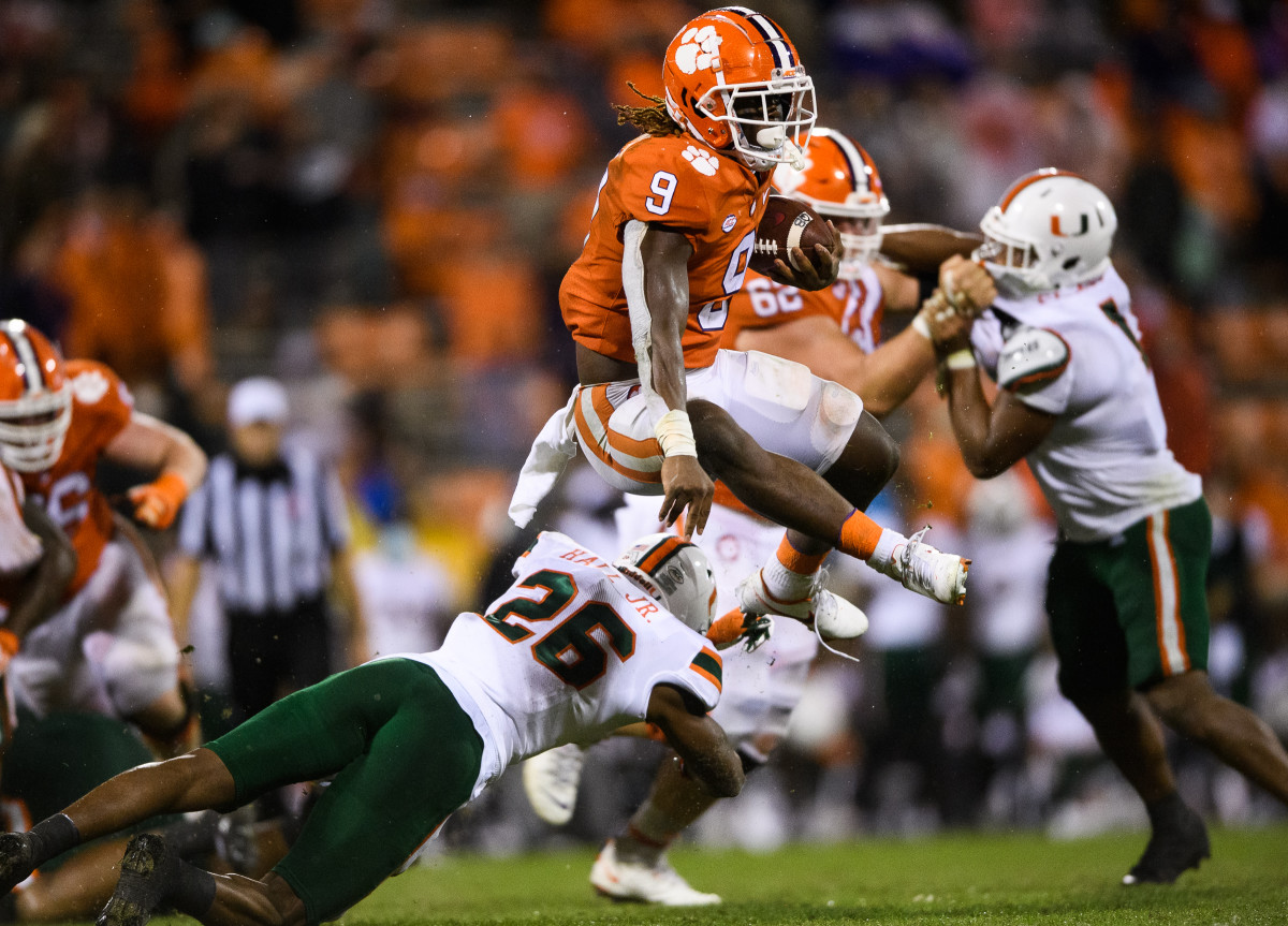 Clemson Tigers running back Travis Etienne (9) leaps over Miami Hurricanes safety Gurvan Hall, Jr. (26) during the third quarter at Memorial Stadium.
