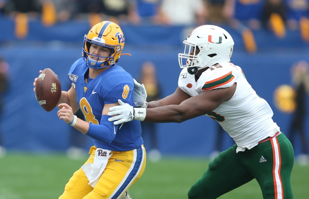 Pittsburgh Panthers quarterback Kenny Pickett (8) is chased by Miami Hurricanes defensive lineman Gregory Rousseau (15) during the first quarter at Heinz Field.