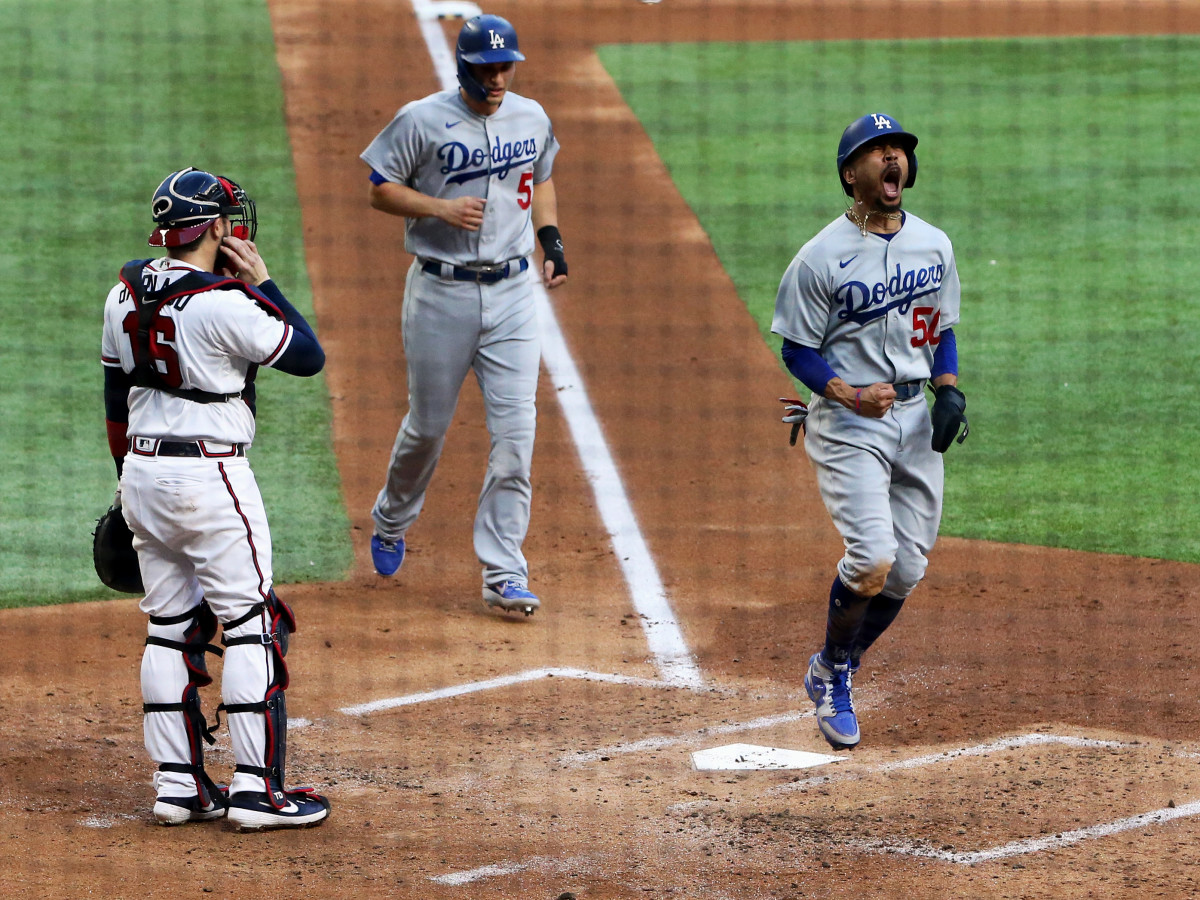 Oct 14, 2020; Arlington, Texas, USA; Los Angeles Dodgers right fielder Mookie Betts (50) celebrates after scoring against Atlanta Braves catcher Travis d'Arnaud (16) during game three of the 2020 NLCS at Globe Life Field.