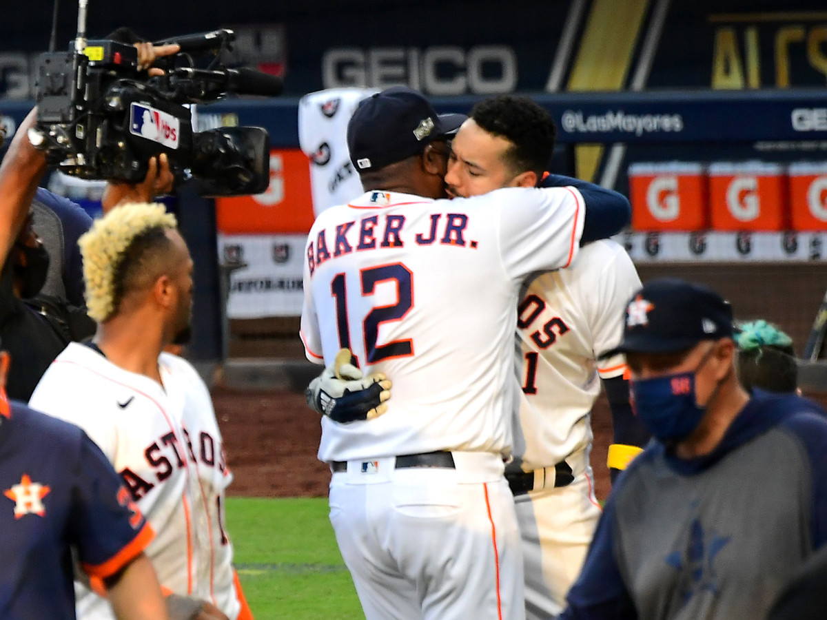 Oct 15, 2020; San Diego, California, USA; Houston Astros shortstop Carlos Correa (1) is embraced by manager Dusty Baker (12) after hitting a walk off solo home run in the ninth inning of game five of the 2020 ALCS to defeat the Tampa Bay Rays at Petco Park.