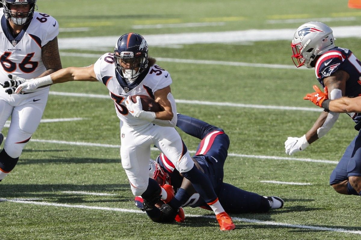 Denver Broncos running back Phillip Lindsay (30) runs past New England Patriots linebacker Ja'Whaun Bentley (51) during the first quarter at Gillette Stadium.