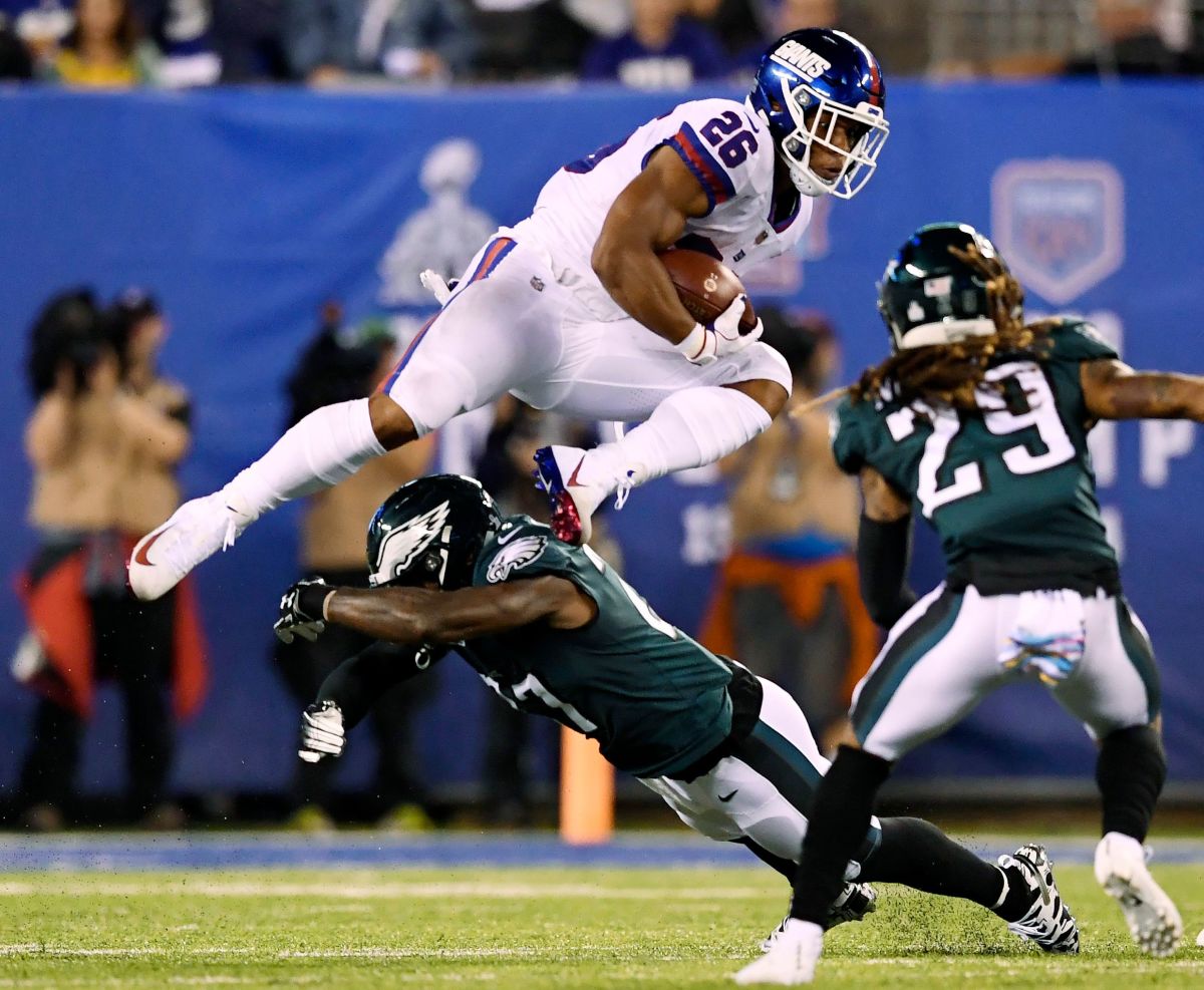 New York Giants running back Saquon Barkley (26) jumps over an Eagles defender in the first half. The New York Giants face the Philadelphia Eagles on Thursday, Oct. 11, 2018, in East Rutherford. Poy 2018