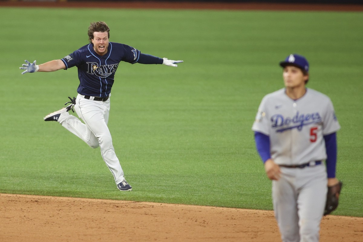 Oct 24, 2020; Arlington, Texas, USA; Tampa Bay Rays right fielder Brett Phillips (14) celebrates after driving in the winning run as Los Angeles Dodgers shortstop Corey Seager (5) looks on during the ninth inning of game four of the 2020 World Series at Globe Life Field. Mandatory Credit: Tim Heitman-USA TODAY Sports
