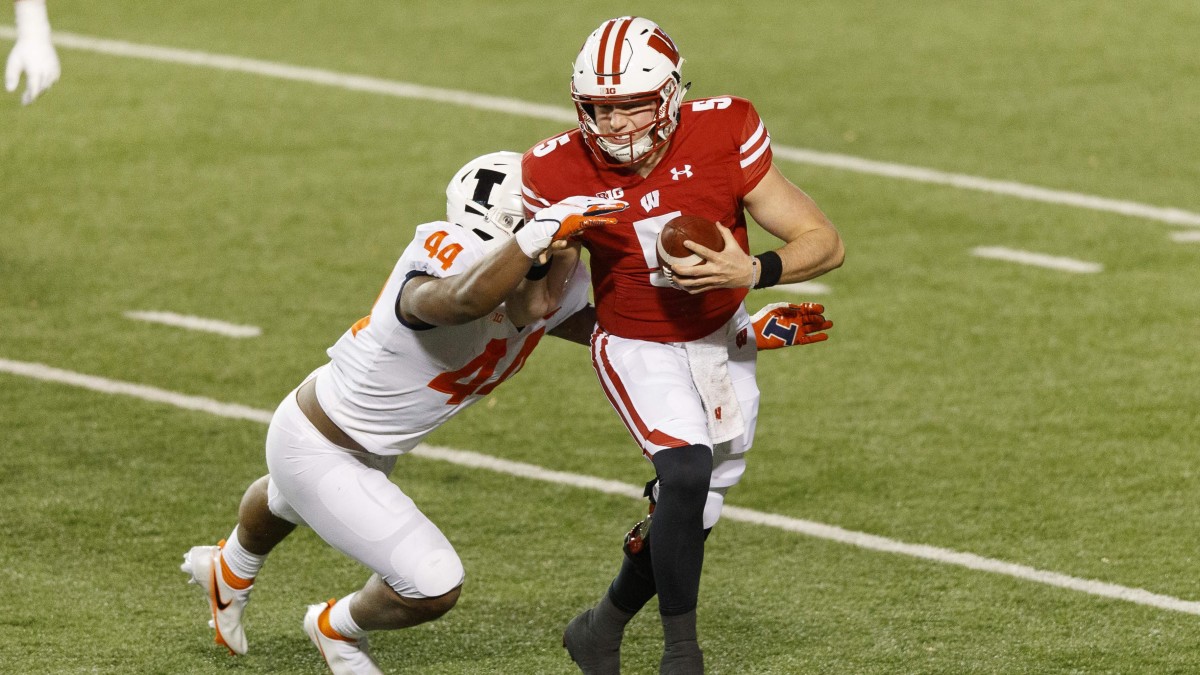 Wisconsin Badgers quarterback Graham Mertz (5) is tackled by Illinois Fighting Illini linebacker Tarique Barnes (44) during the second quarter at Camp Randall Stadium.