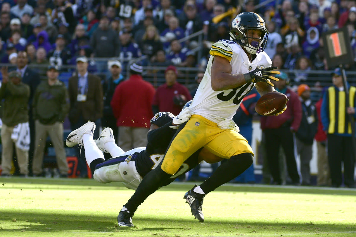 Former Steelers running back James Conner (30) runs as Ravens inside linebacker Kenny Young (40) dives for a tackle attempt in the second quarter of a 2018 game.