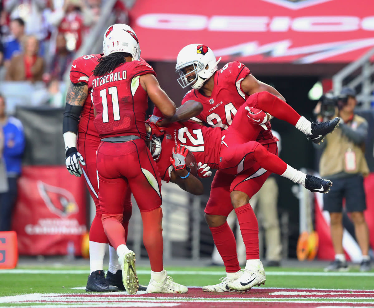 Cardinals wide receiver John Brown (12) is lifted by tight end Jermaine Gresham (84) as he celebrates a third-quarter touchdown with Larry Fitzgerald (11) against the Giants.