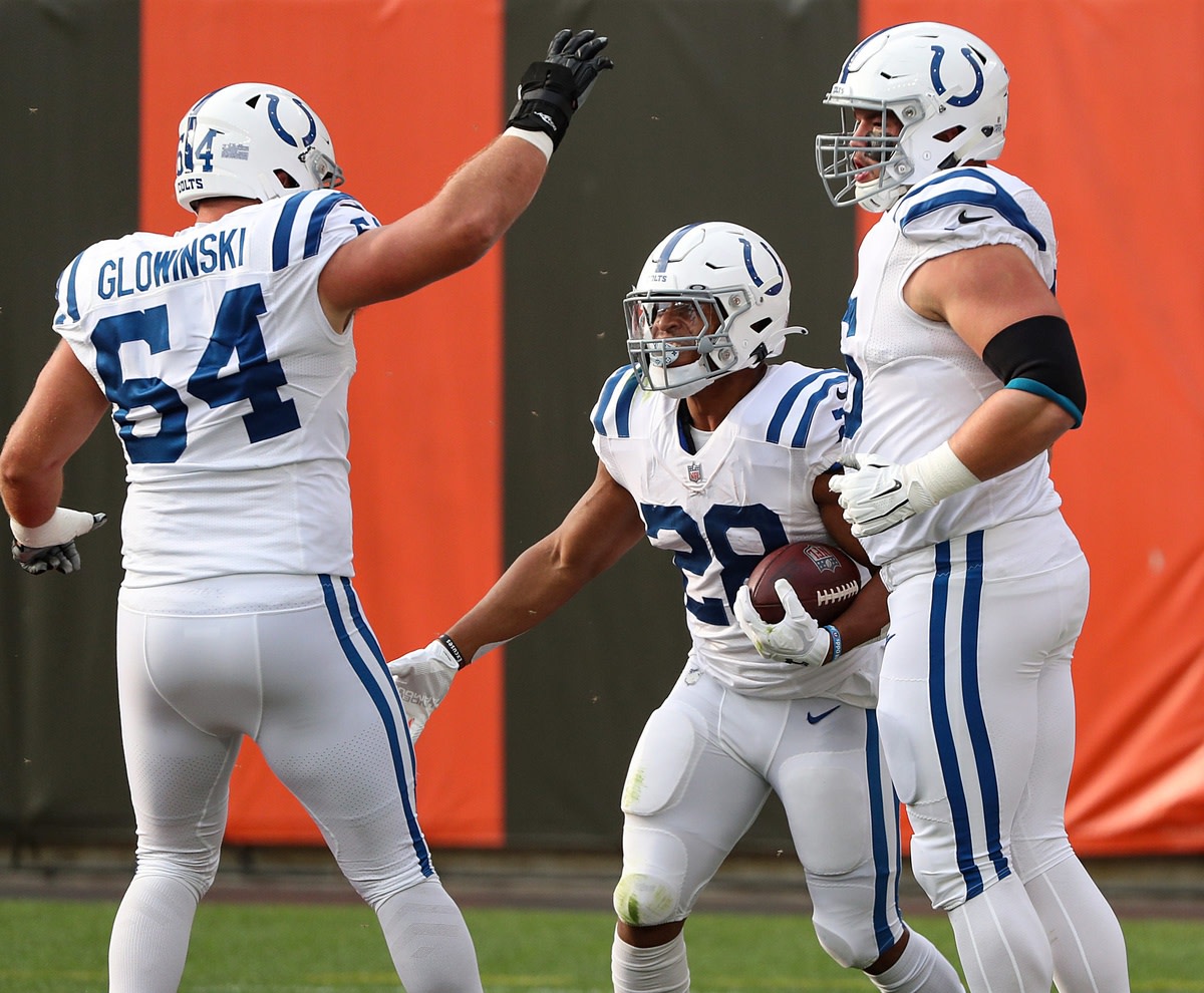 Indianapolis Colts rookie running back Jonathan Taylor (28) celebrates a touchdown run at Cleveland with guards Mark Glowinski (64) and Quenton Nelson.