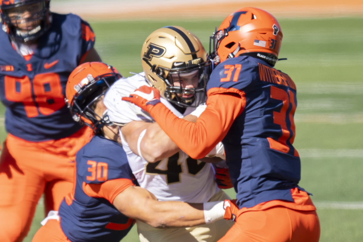 Illinois Fighting Illini defensive back Sydney Brown (left) and defensive back Devon Witherspoon (right) tackle Purdue Boilermakers running back Zander Horvath (center) during the first half at Memorial Stadium.