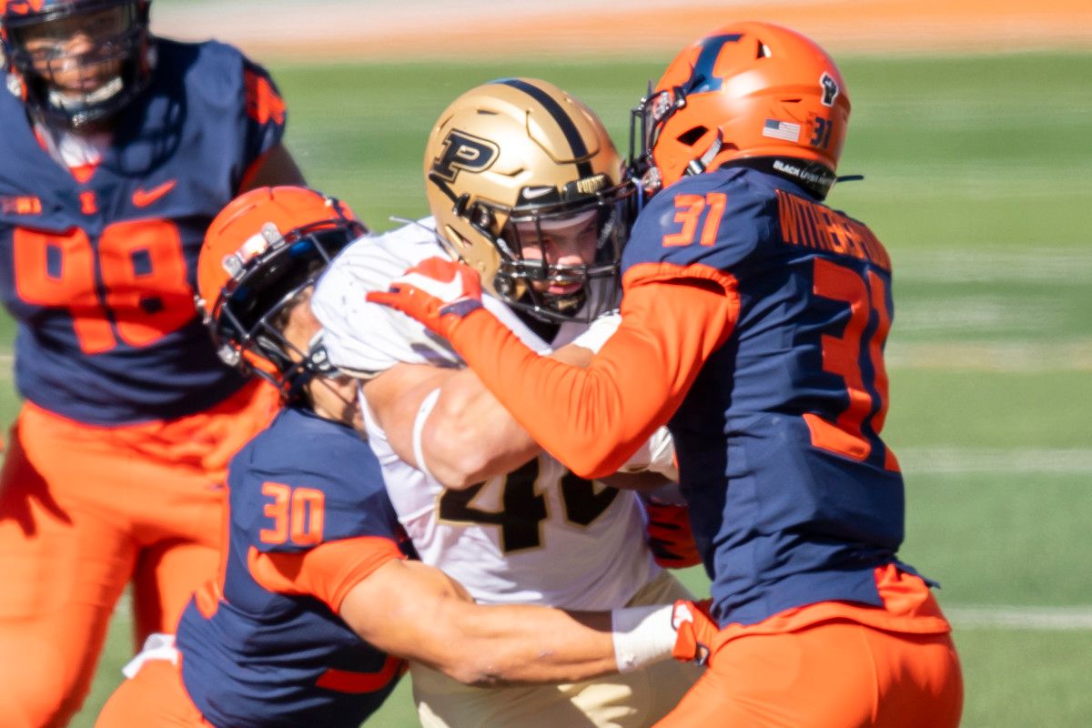 Illinois Fighting Illini defensive back Sydney Brown (left) and defensive back Devon Witherspoon (right) tackle Purdue Boilermakers running back Zander Horvath (center) during the first half at Memorial Stadium.