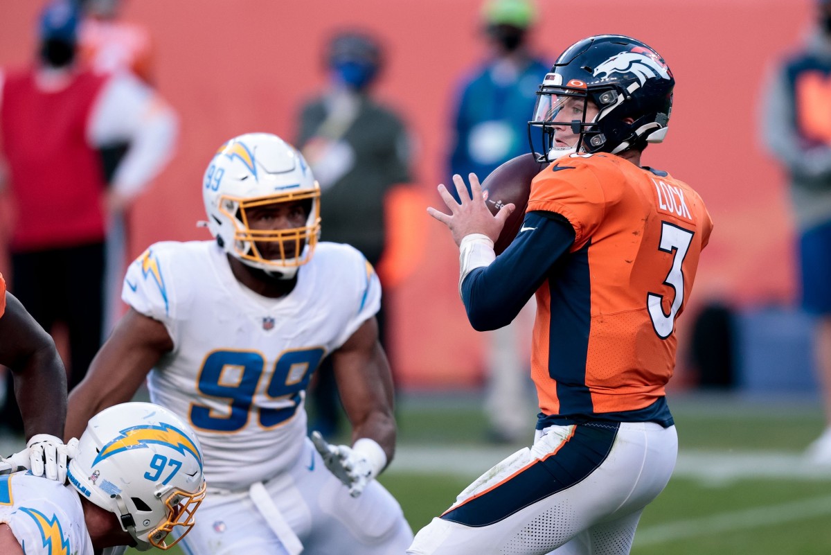 Denver Broncos quarterback Drew Lock (3) looks to pass under pressure from Los Angeles Chargers defensive tackle Jerry Tillery (99) in the third quarter at Empower Field at Mile High.