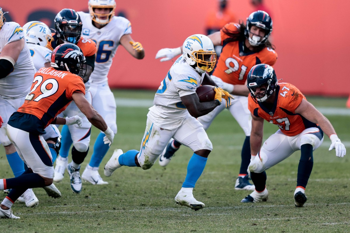 Los Angeles Chargers running back Troymaine Pope (35) runs the ball against Denver Broncos inside linebacker Josey Jewell (47) and cornerback Bryce Callahan (29) in the third quarter at Empower Field at Mile High.