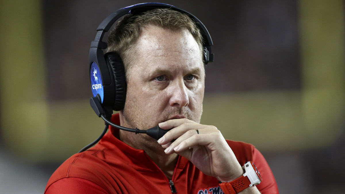 Hugh Freeze talks into a headset during an Ole Miss football game