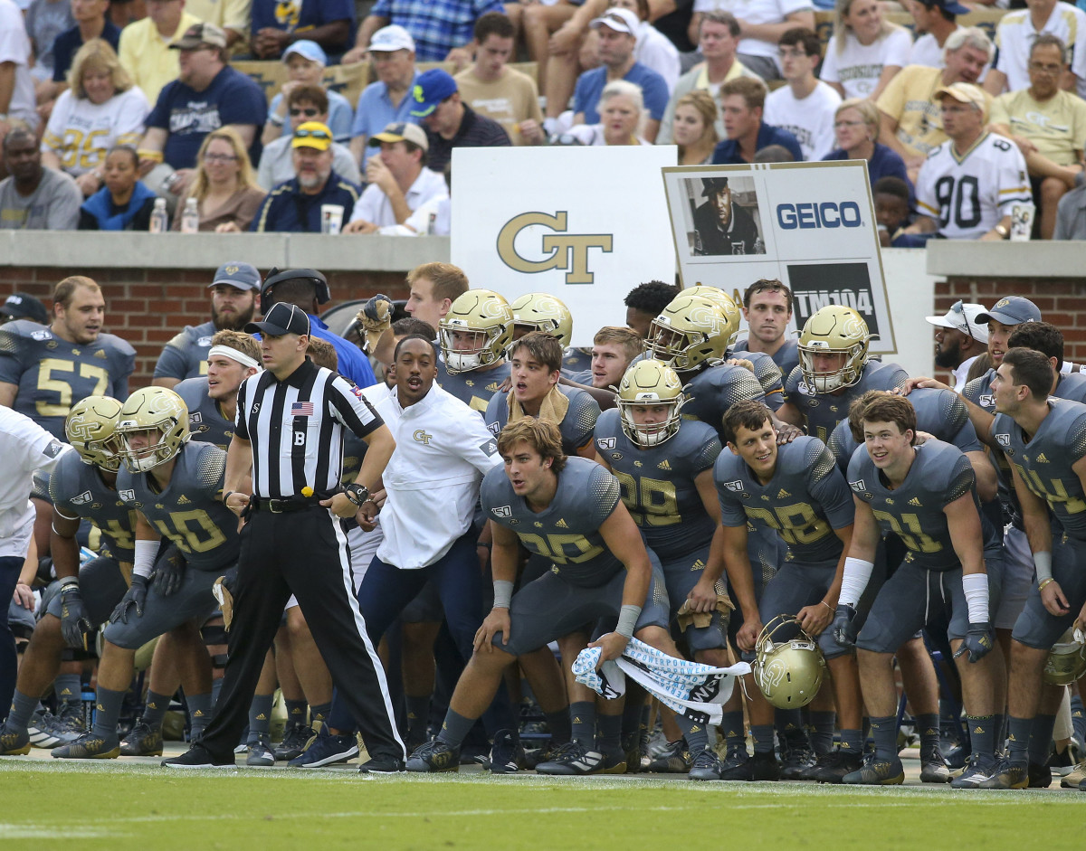 Georgia Tech football holds up signs for play calls on the sideline