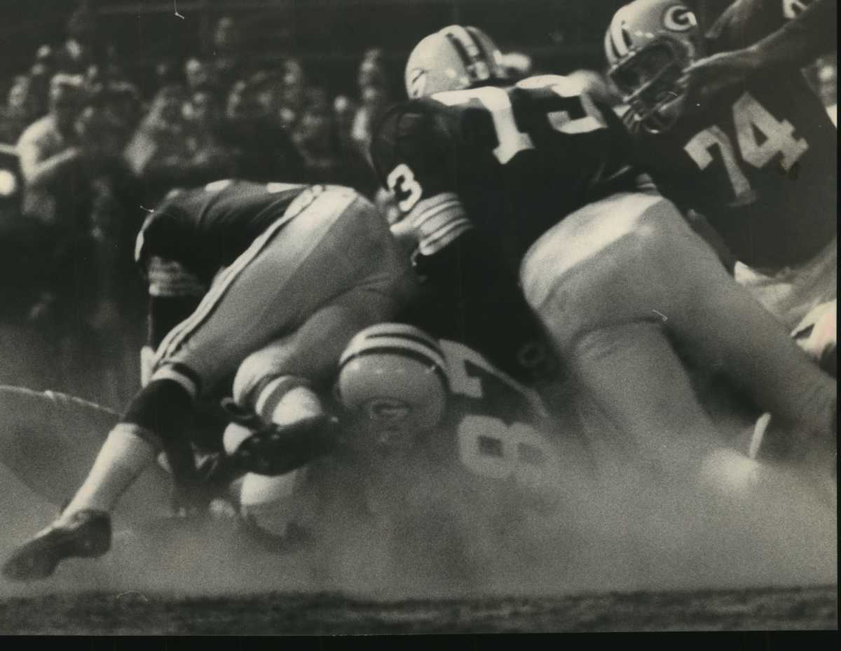 Under that pile of Packers is Bears running back Gale Sayers, buried on a play during the Midwest Shrine Game at Milwaukee's County Stadium on Aug. 12, 1966. Sayers couldn't gain much ground, but Chicago still beat Green Bay 13–10.