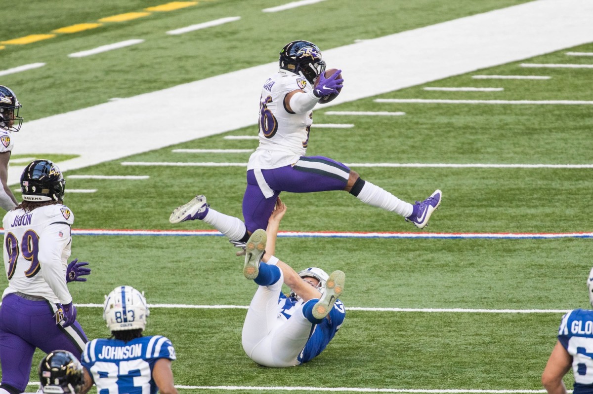 Baltimore Ravens safety Chuck Clark leaps over Indianapolis Colts quarterback Philip Rivers during a 65-yard TD fumble return in Sunday's 24-10 Ravens road win at Lucas Oil Stadium.