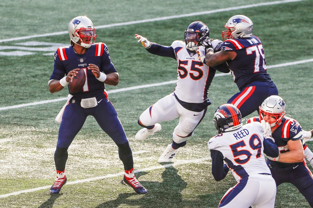 New England Patriots quarterback Cam Newton (1) looks downfield as offensive tackle Isaiah Wynn (76) tries to keep Denver Broncos linebacker Bradley Chubb (55) away during the second half at Gillette Stadium.