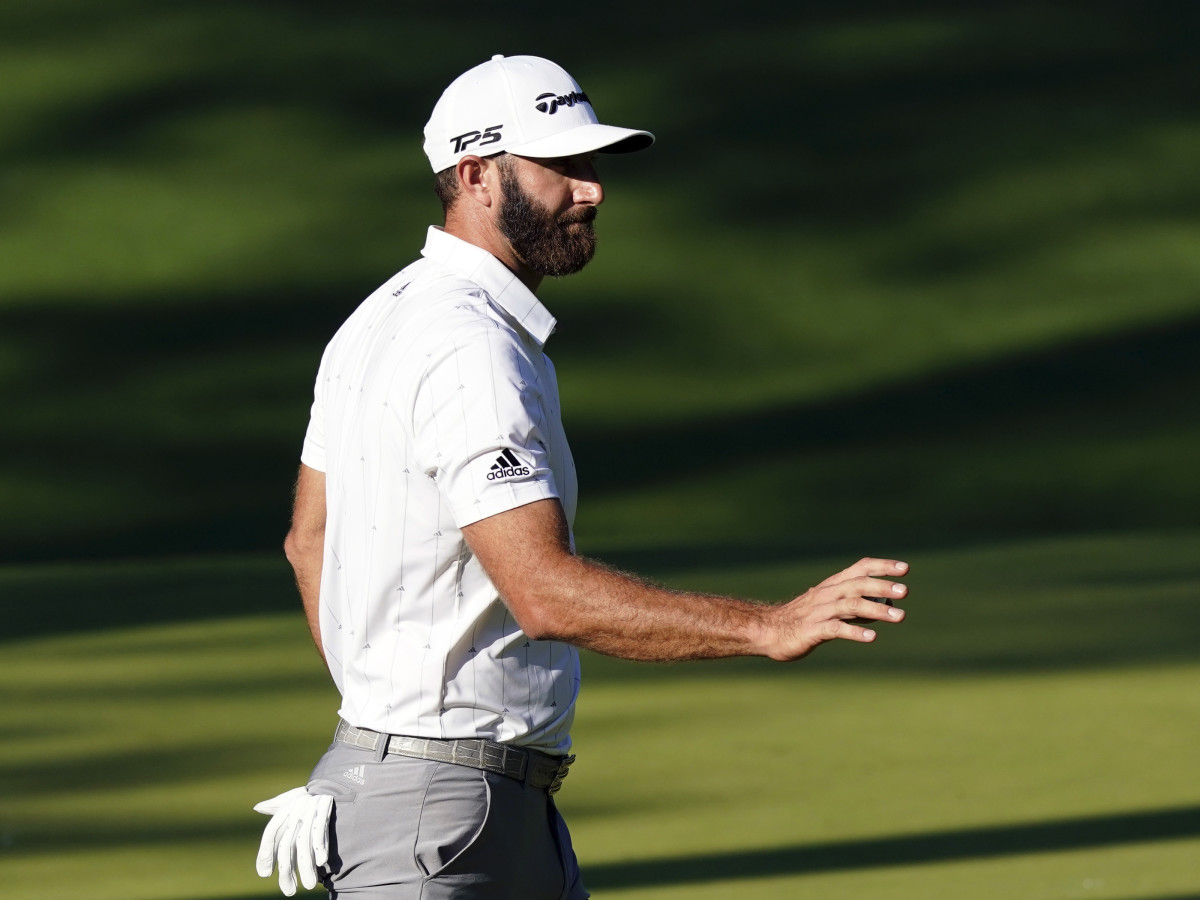 Dustin Johnson waves after his putt on the tenth green during the third round of The Masters