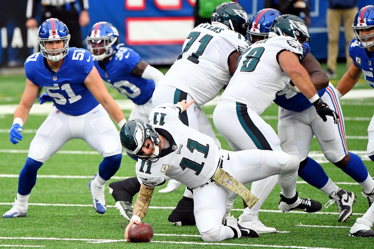 Nov 15, 2020; East Rutherford, New Jersey, USA; Philadelphia Eagles quarterback Carson Wentz (11) trips on a play against the New York Giants during the first half at MetLife Stadium.