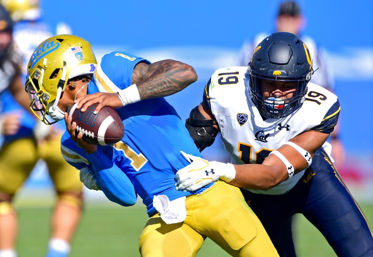 UCLA quarterback Dorian Thompson-Robinson tries to elude Cal linebacker Cameron Goode.