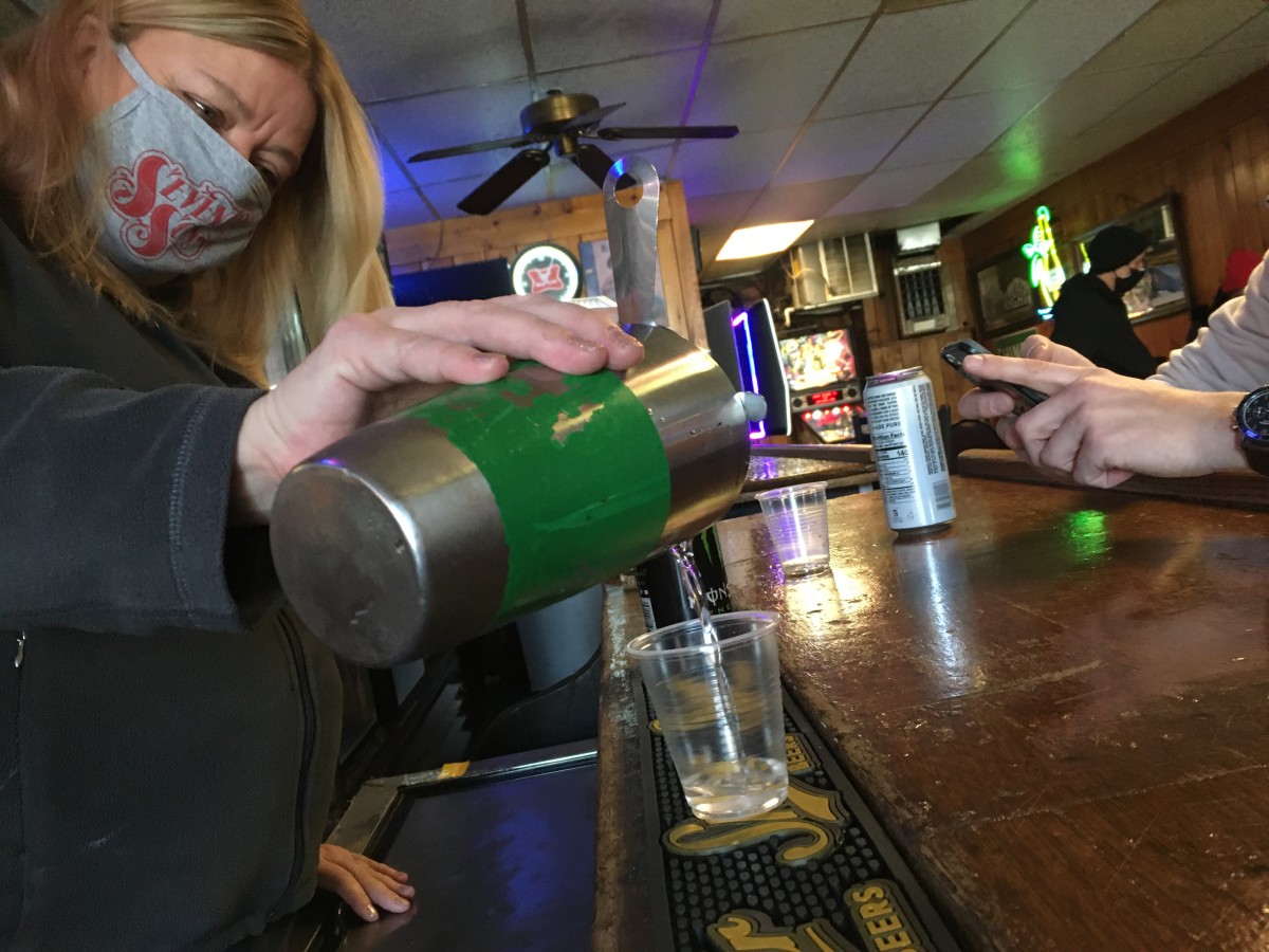 Sharon Lyons, a bartender at Mike's in Columbus, pours a shot for her regular customers on Thursday morning