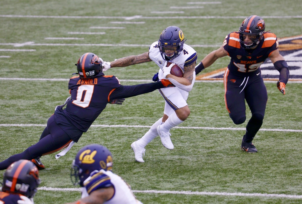 Nikko Remigio tries to elude a tackler on a return against Oregon State