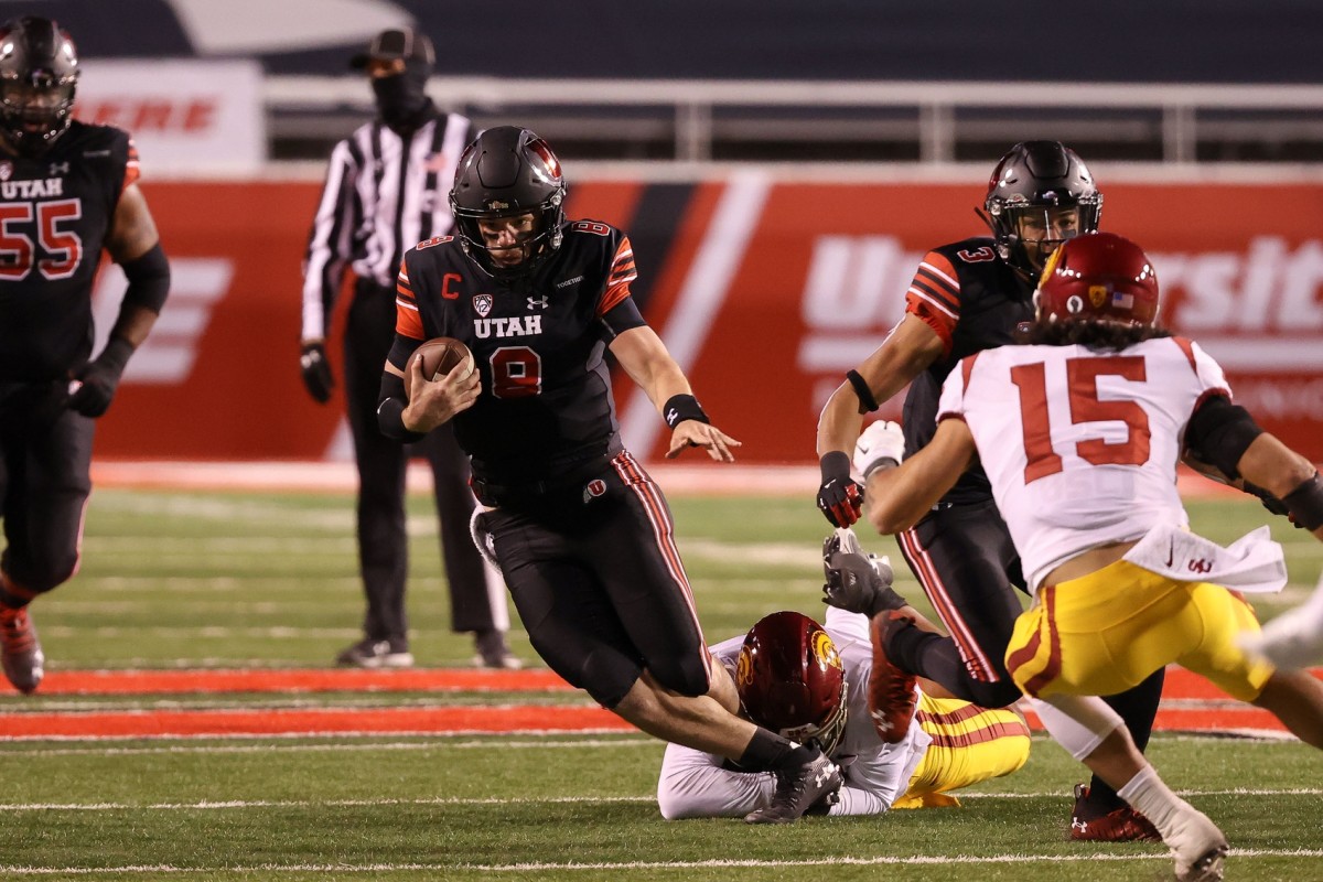 Nov 21, 2020; Salt Lake City, Utah, USA; Utah Utes quarterback Jake Bentley (8) is tackled by USC Trojans linebacker Hunter Echols (31) while running up the field during the second half at Rice-Eccles Stadium. USC Trojans won 33-17.