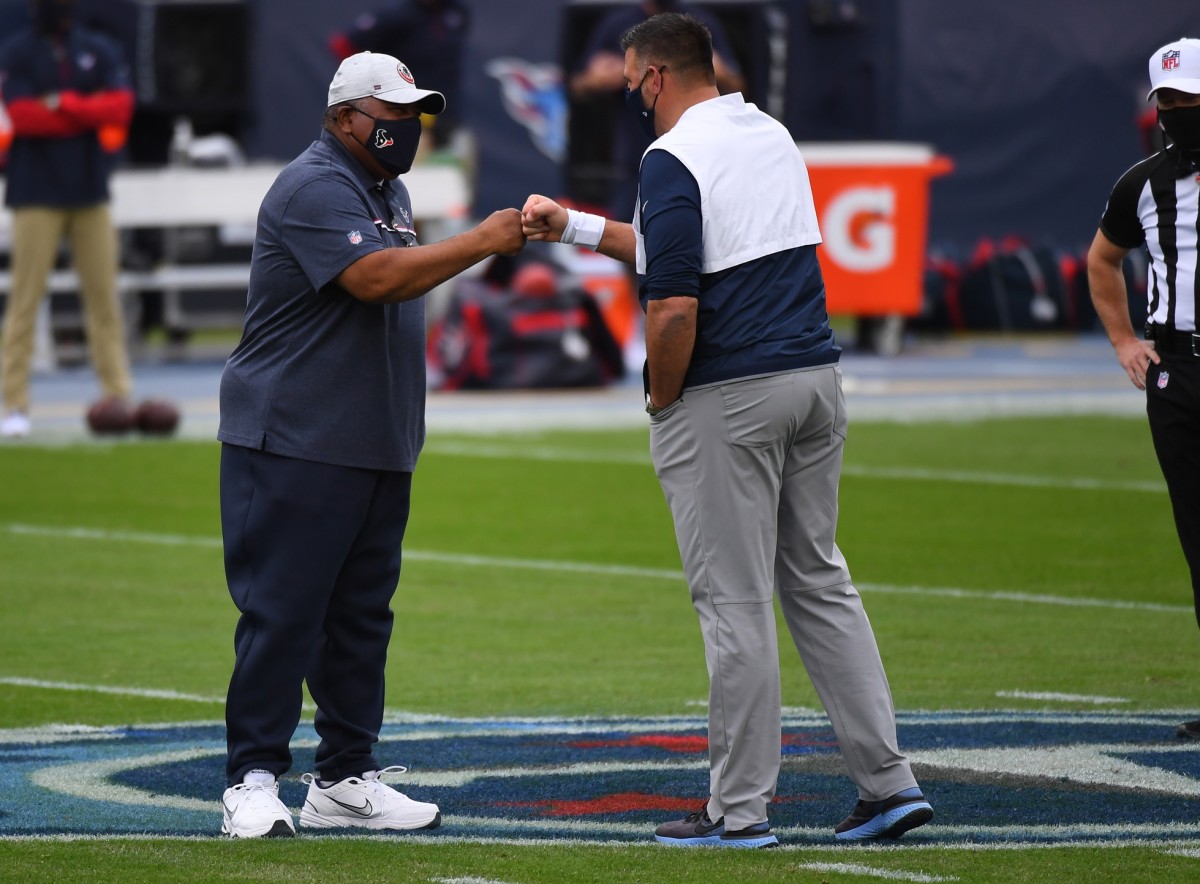 Interim Houston Texans head coach Romeo Crennel bumps fists with Tennessee Titans head coach Mike Vrabel.