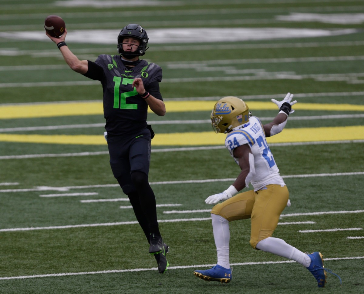 Oregon Ducks quarterback Tyler Shough (12) passes while being pressured by UCLA Bruins defensive back Qwuantrezz Knight (24) during the third quarter of the Pac12 Conference game at Autzen Stadium in Eugene, Oregon on November, 21, 2020.