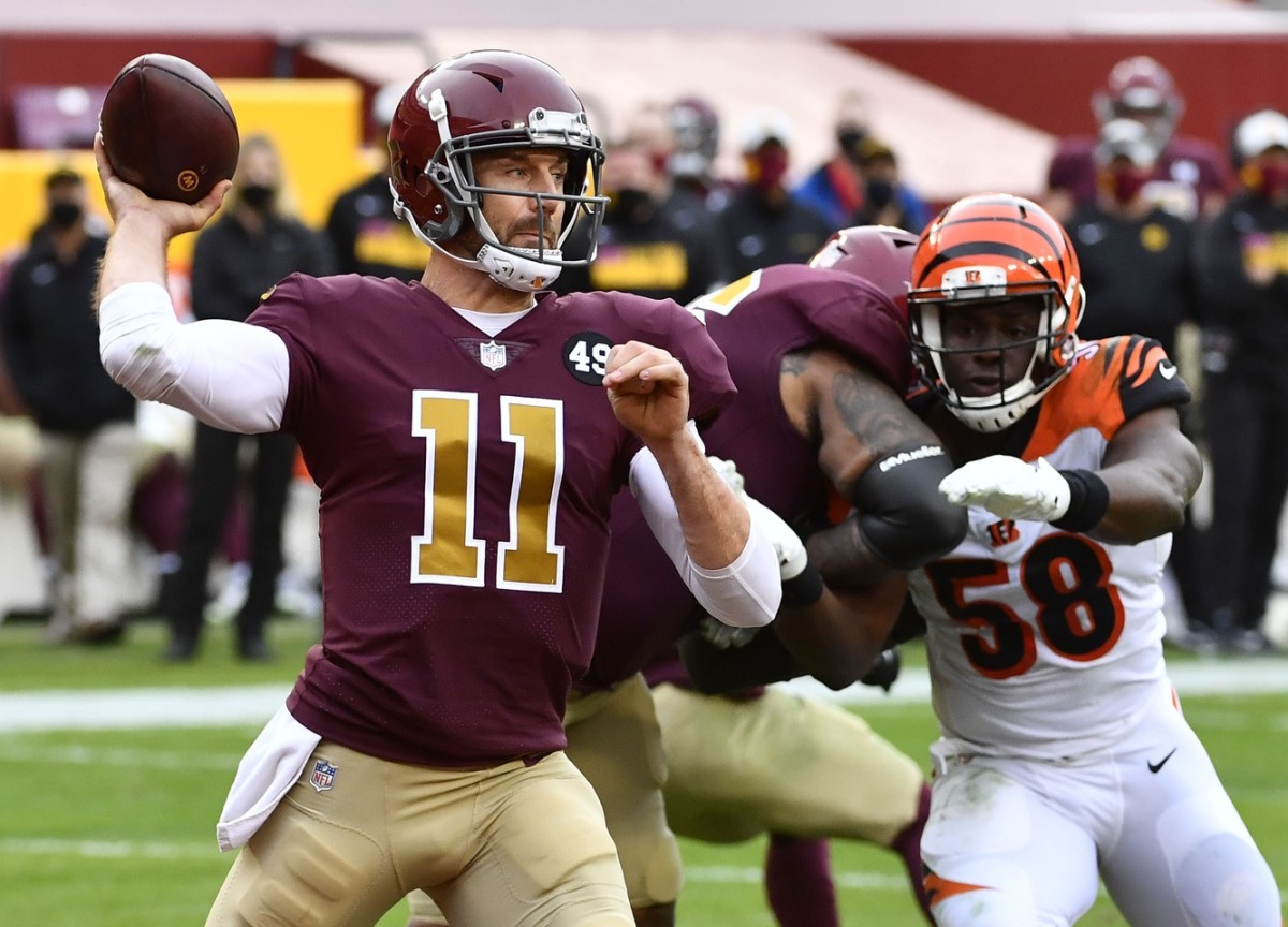 Nov 22, 2020; Landover, Maryland, USA; Washington Football Team quarterback Alex Smith (11) throws a pass as Cincinnati Bengals defensive end Carl Lawson (58) rushes during the second half at FedExField.