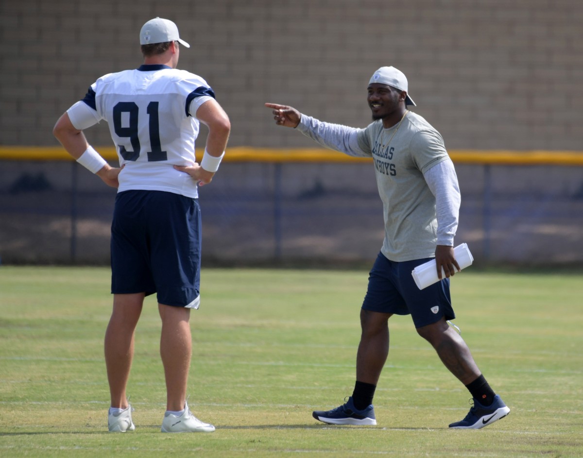 Aug 17, 2018; Oxnard, CA, USA: Dallas Cowboys strength and conditioning coach Markus Paul (right) talks with long snapper Louis-Philippe Ladouceur (91) during training camp at River Ridge Fields.