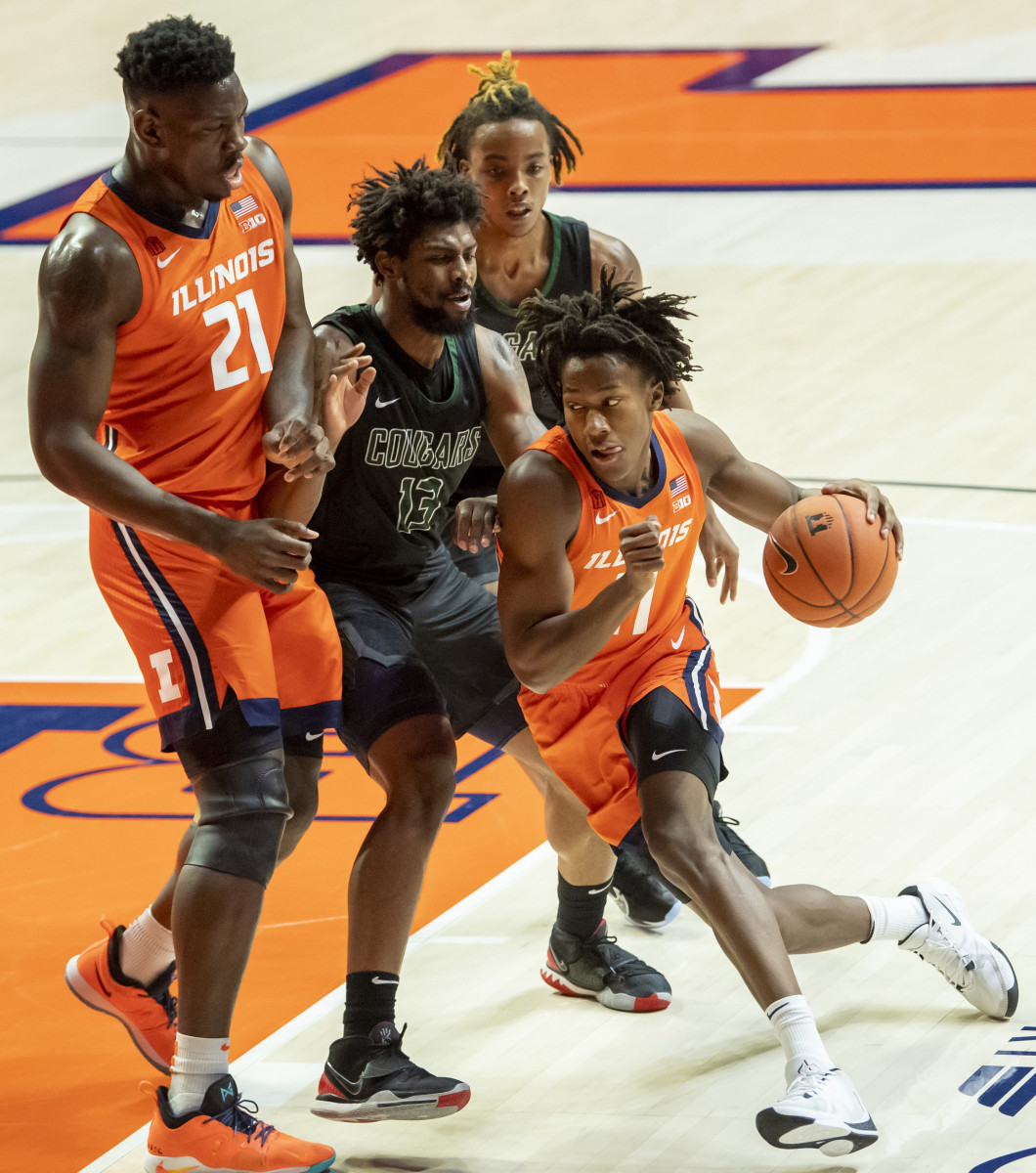 Illinois Fighting Illini guard Ayo Dosunmu (11) drives against Chicago State Cougars forward Aaris-Monte Bonds (13) as center Kofi Cockburn (21) defends during the first half at the State Farm Center.