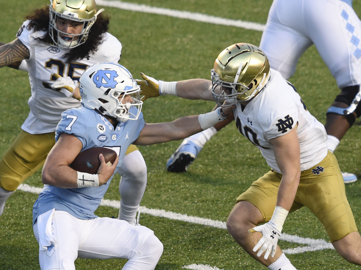 North Carolina Tar Heels quarterback Sam Howell (7) is sacked by Notre Dame Fighting Irish linebacker Marist Liufau (35) and linebacker Drew White (40) in the second quarter at Kenan Memorial Stadium.