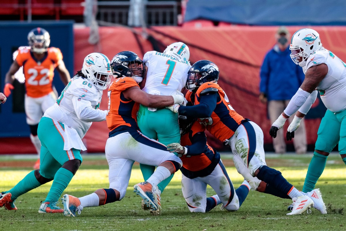 Nov 22, 2020; Denver, Colorado, USA; Miami Dolphins quarterback Tua Tagovailoa (1) is sacked by Denver Broncos defensive end DeMarcus Walker (57) and outside linebacker Bradley Chubb (55) and outside linebacker Malik Reed (59) in the second quarter at Empower Field at Mile High. Mandatory Credit: Isaiah J. Downing-USA TODAY 