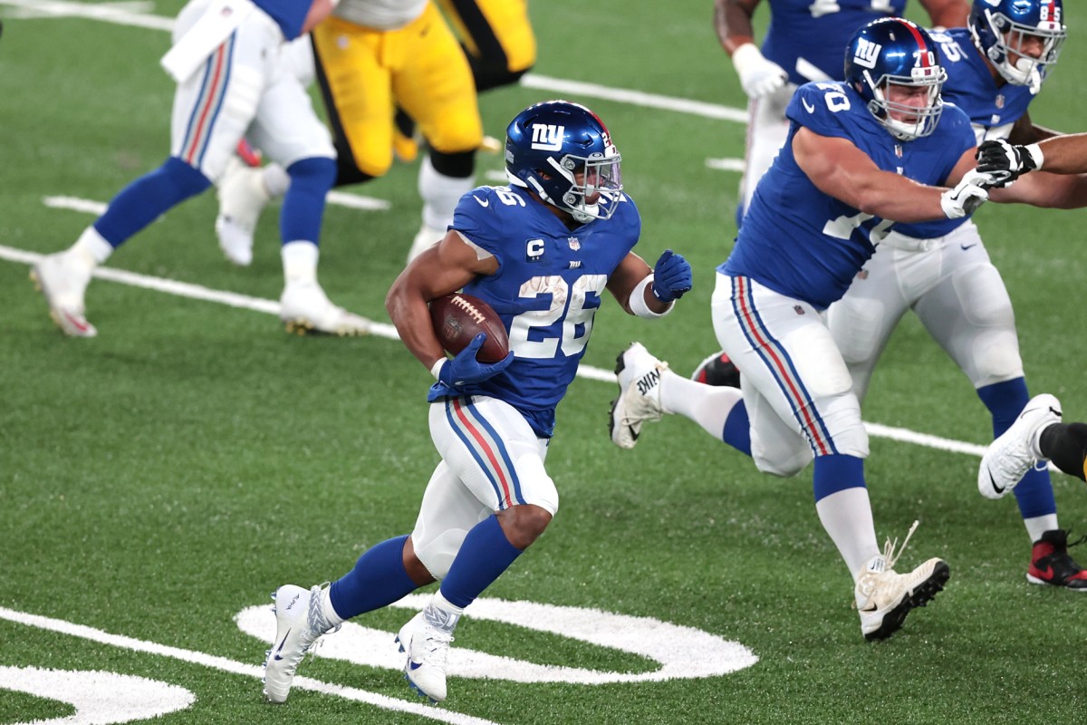 Sep 14, 2020; East Rutherford, New Jersey, USA; New York Giants running back Saquon Barkley (26) carries the ball against the Pittsburgh Steelers as offensive guard Kevin Zeitler (70) blocks during the second half at MetLife Stadium.