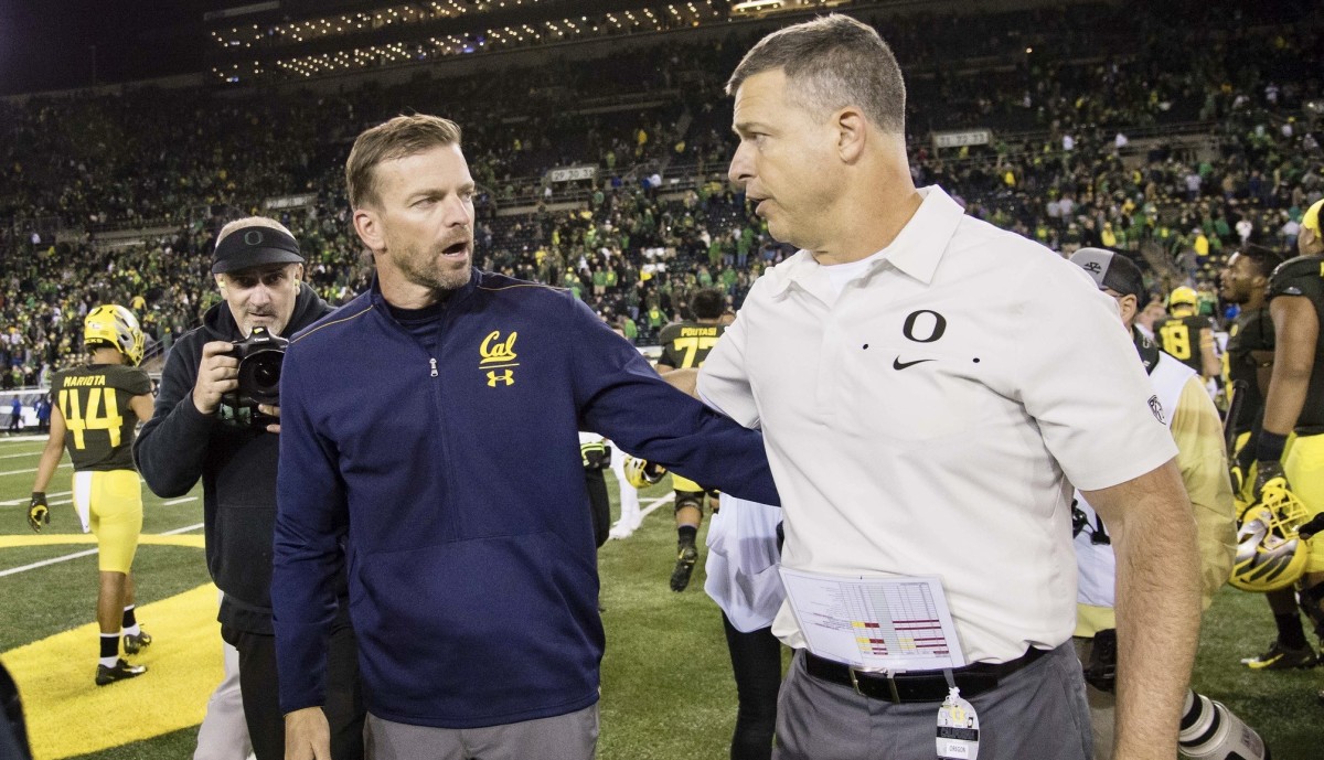 Coaches Justin Wilcox of Cal and Mario Cristobal of Oregon meet after last year's game.